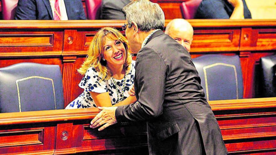 El consejero de Hacienda, Román Rodríguez, habla con su predecesora, Rosa Dávila, en el Parlamento.