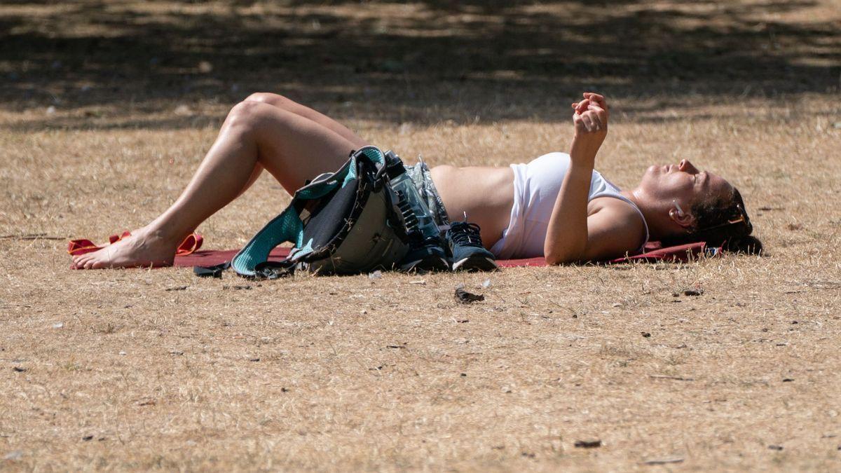 Una mujer, tumbada en un parque de Londres durante la ola de calor.