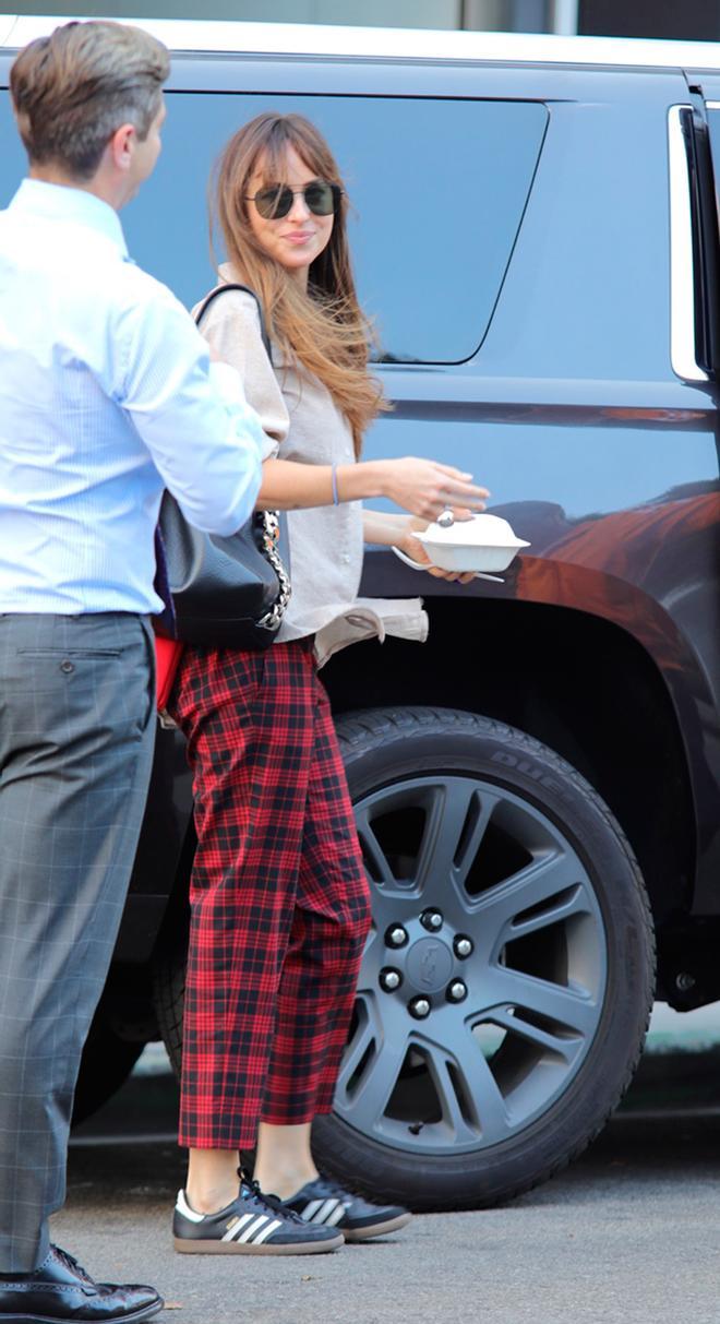 Dakota Johnson con pantalones de tartán rojo
