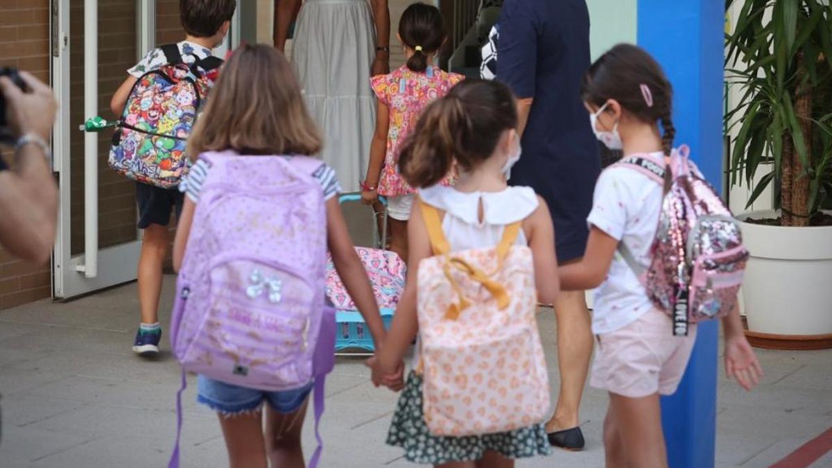 Varios niños entran al centro escolar el primer día de colegio en Alicante.