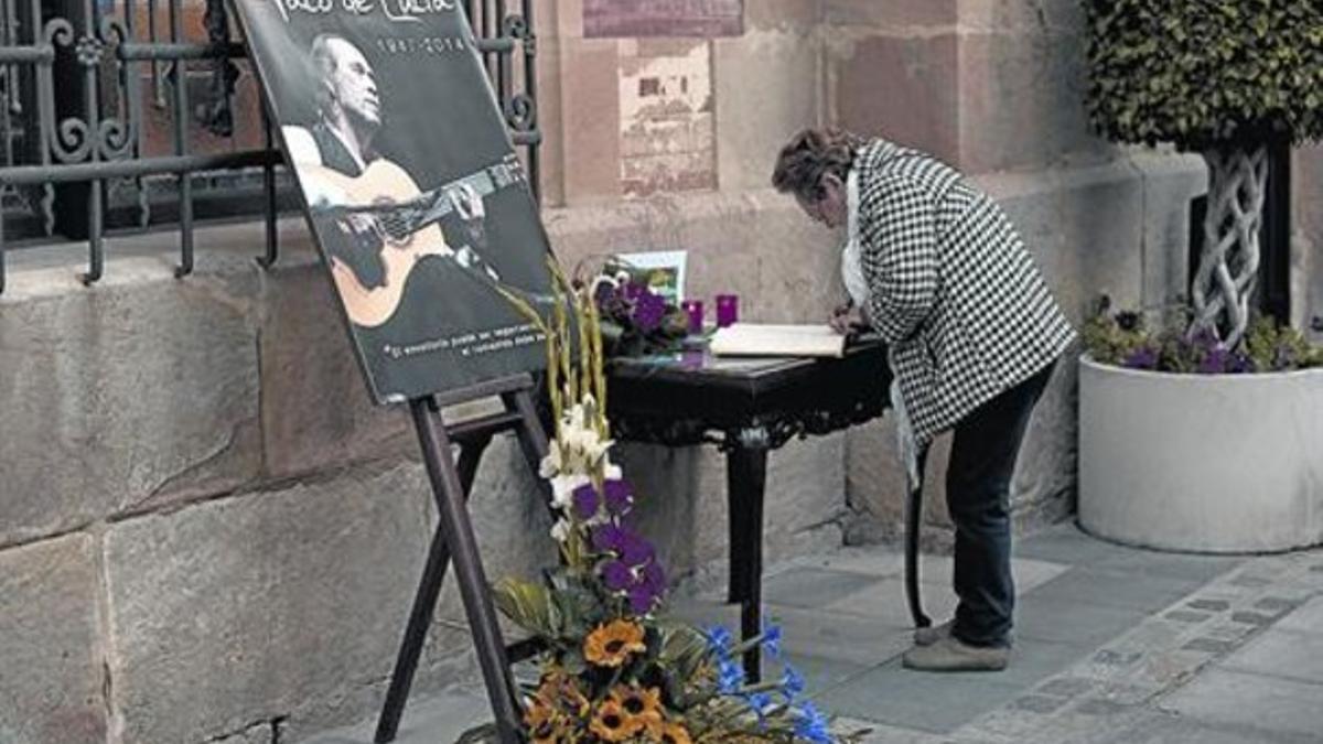 Condolencias 8 Una admiradora del tocaor, firmando ayer en Algeciras el libro expuesto en el Ayuntamiento.
