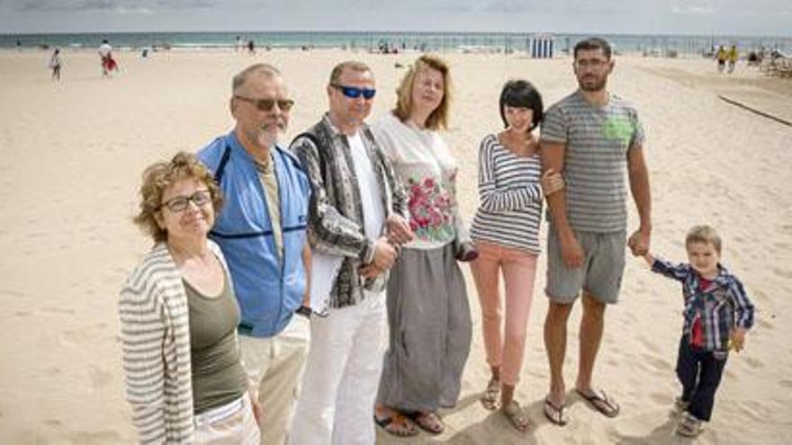 Un grupo de turistas rusos, que pasan estos días sus vacaciones en Gandia, posan ayer para Levante-EMV sobre la arena de la playa Nord.