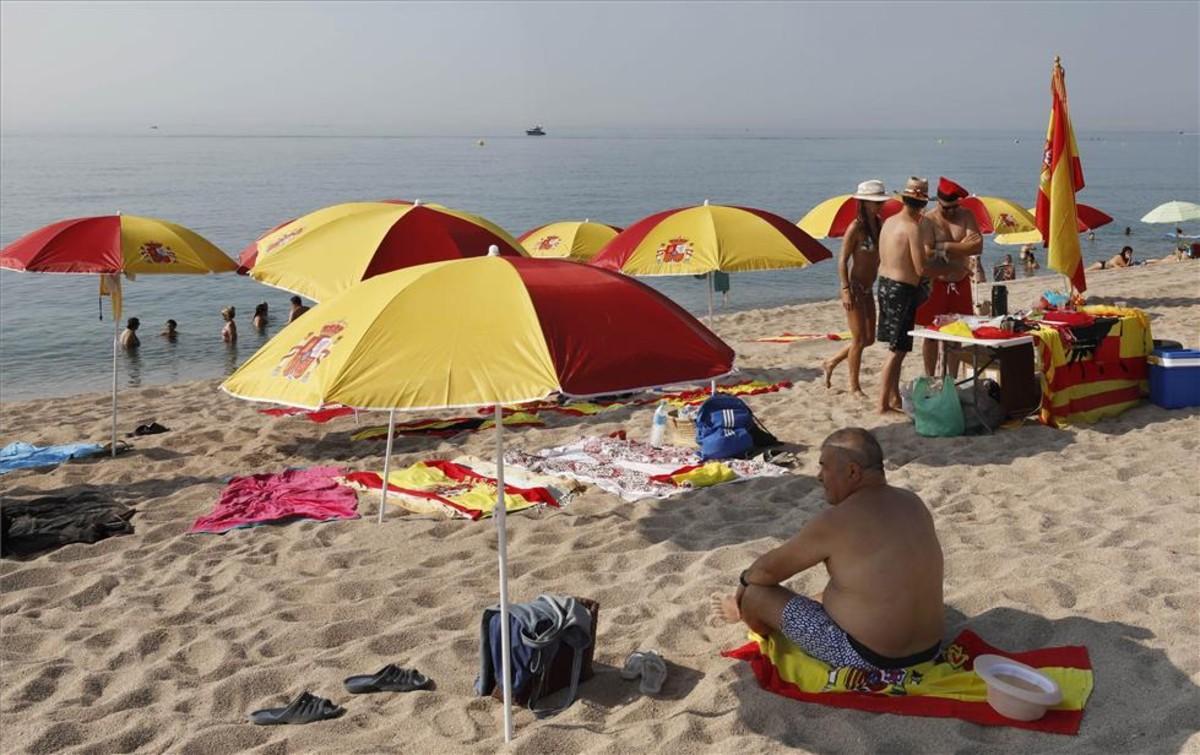 Sombrillas con los colores de la bandera de España en una playa de Arenys de Mar.
