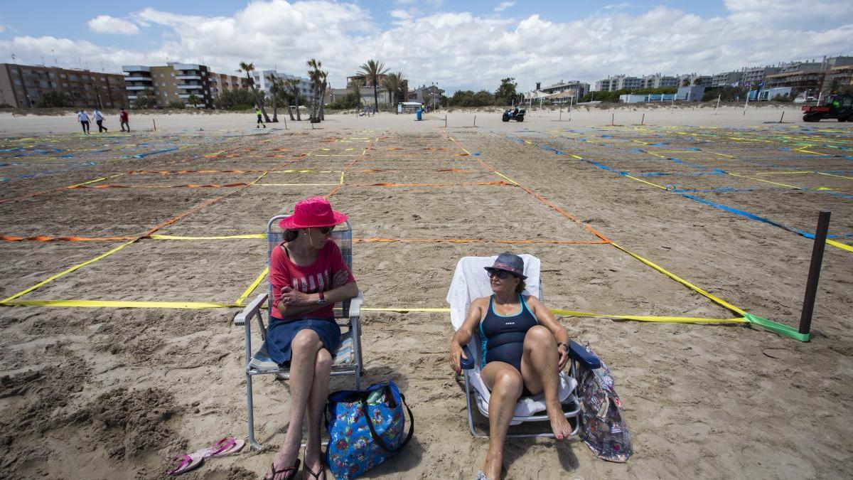 Dos mujeres disfrutan de un día de playa en Canet d&#039;En Berenguer, donde ya se ha parcelado la playa.