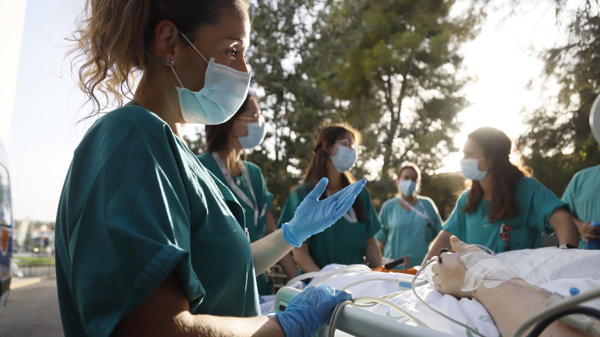 La especialista en Medicina Intensiva del hospital Reina Sofía, Cristina López, en primer plano, durante uno de los paseos con un paciente de la uci. 