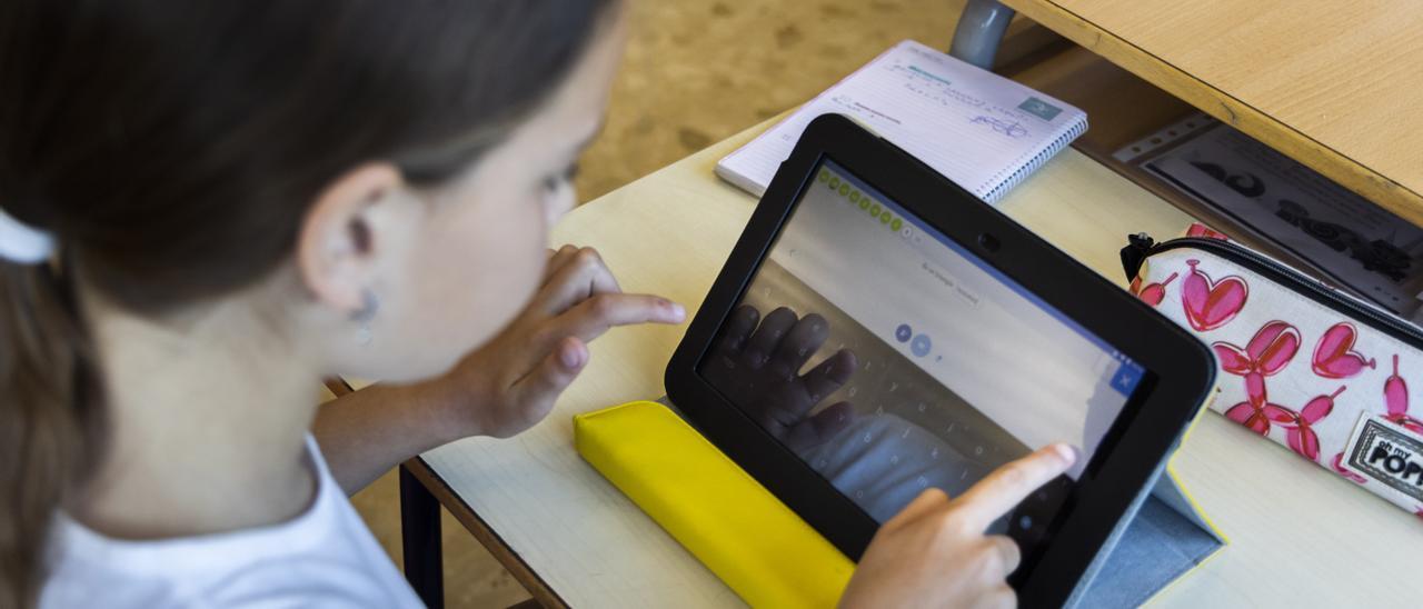 Una alumna trabaja en clase con una tableta.