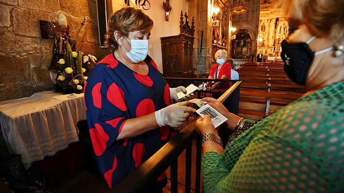 Reparto de estampillas de San Benito entre los fieles que acudieron ayer a Lérez.