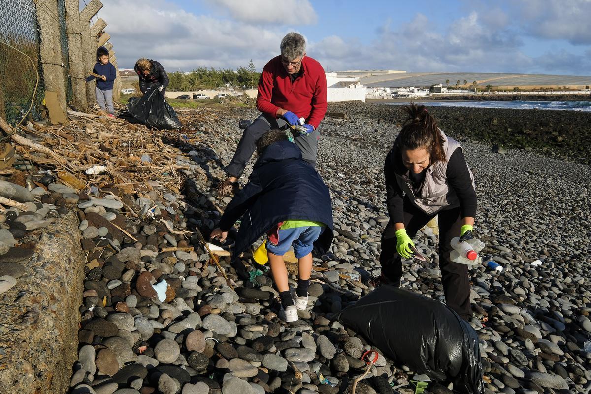 Un grupo de familias voluntarias ayudan a recoger los desperdicios acumulados junto a la playa.