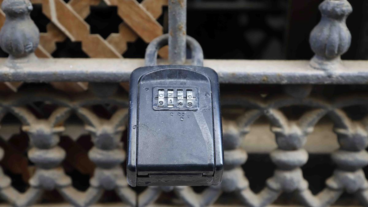 Un candado de una vivienda turística en una verja en Málaga.