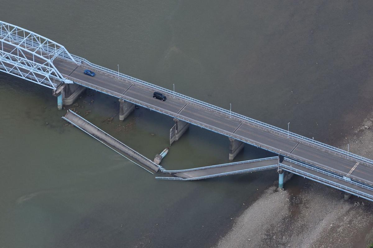Los automóviles conducen en el puente Ueyanagi parcialmente colapsado en Yatsushiro, prefectura de Kumamoto, el 29 de julio de 2026, después de que un terremoto sacudió el suroeste de Japón el día anterior.