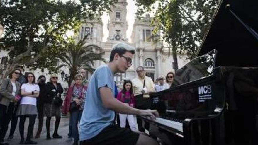 Un joven toca el piano en la plaza del Ayuntamiento.