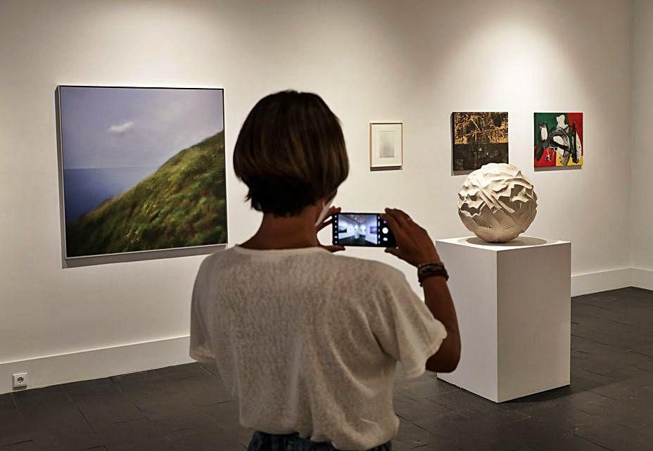 Elsa Fernández, hija del galerista, fotografiando algunas de las obras incluidas en la exposición | Juan Plaza