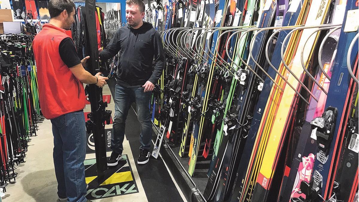Un especialista de la tienda L'Iglú de Barcelona recomienda unos esquís a un cliente