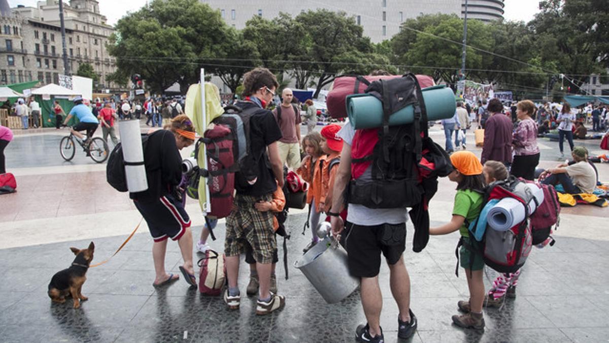 Unos jóvenes, con niños, esta mañana en la plaza de Catalunya.