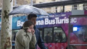 Una pareja se resguarda de la lluvia este marzo en Barcelona