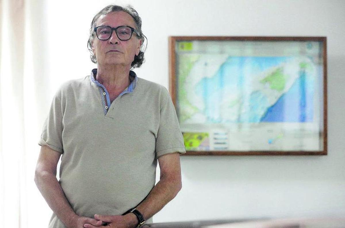 Antoni Garau posa junto a un mapa topobatimétrico del Mar Balear. |  MANU MIELNIEZUK