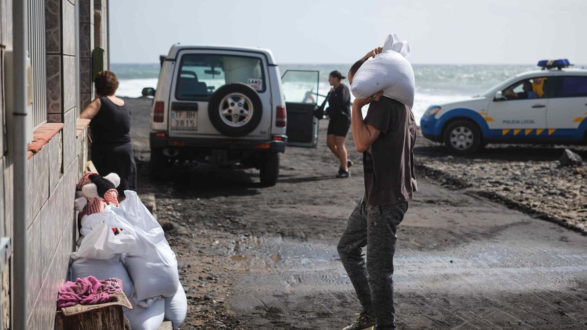 Vecinos en la zona costera de Arafo preparándose para la subida del mar en las próximas horas