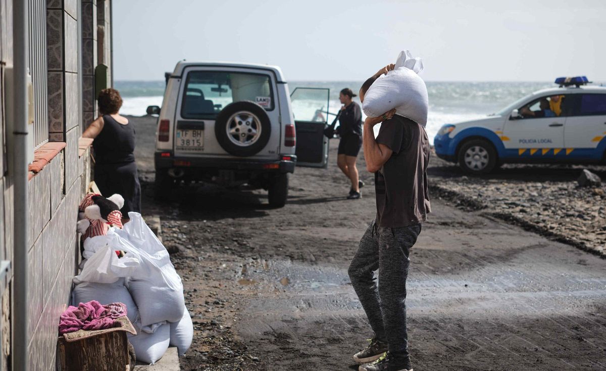 Neighbors in the coastal area of Arafo preparing for the sea to rise in the next few hours