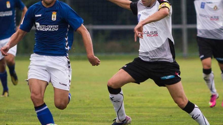 Lucas, del Oviedo B, con el balón, presionado por Javi Sánchez.