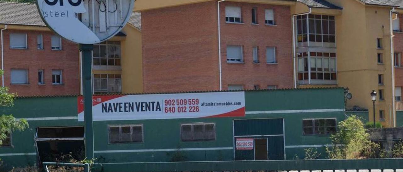 La nave que ocupó Urueña, con el cartel que anuncia su venta, en el polígono de La Cuadriella.