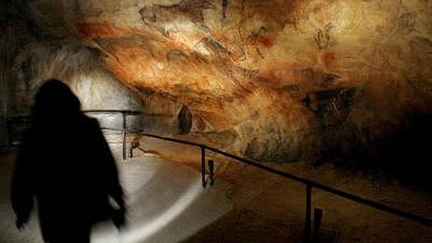 Fotografía de archivo en la que un visitante pasa ante una reproduccion de la Cueva de Tito Bustillo de Ribadesella durante la inauguración del Parque de la Prehistoria de Teverga. .