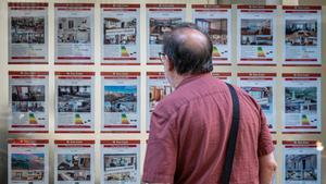 Un vecino mira los anuncios en una inmobiliaria del paseo de Sant Joan.