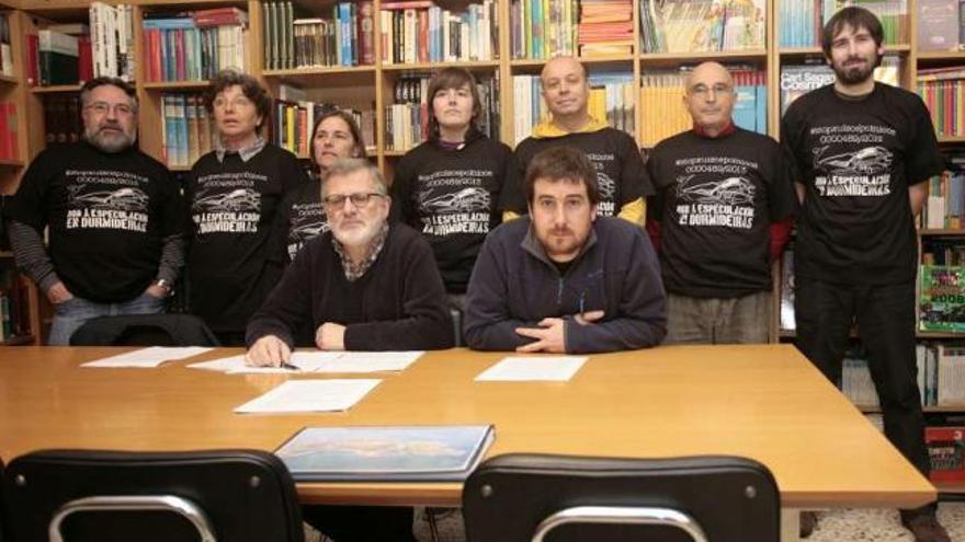 Los denunciados, ayer, con camiseta negra, y sus portavoces, en la biblioteca vecinal. / brais quinteiro