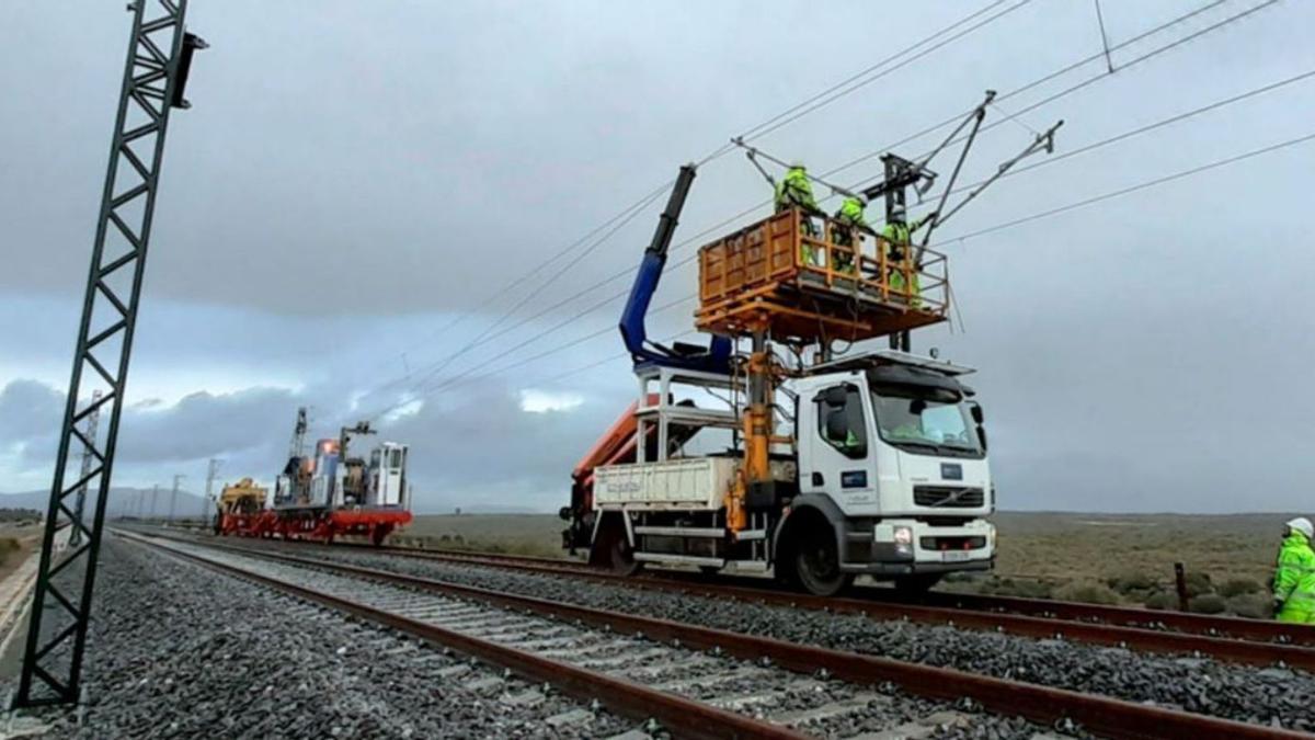 Operaris treballant en una catenària de tren.  | EUROPA PRESS