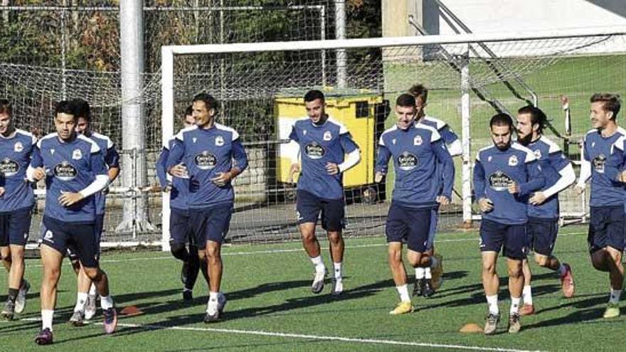 Los futbolistas del Deportivo, sobre el césped sintético del campo de O Monte de San Tirso.