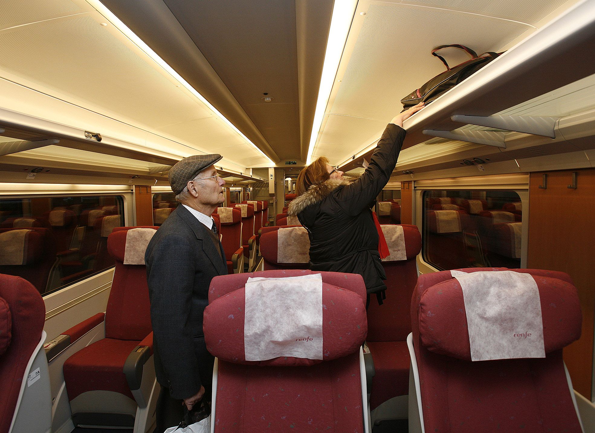 Dos pasajeros colocan sus pertenencias en la zona de butacas del Trenhotel Vigo-Barcelona.