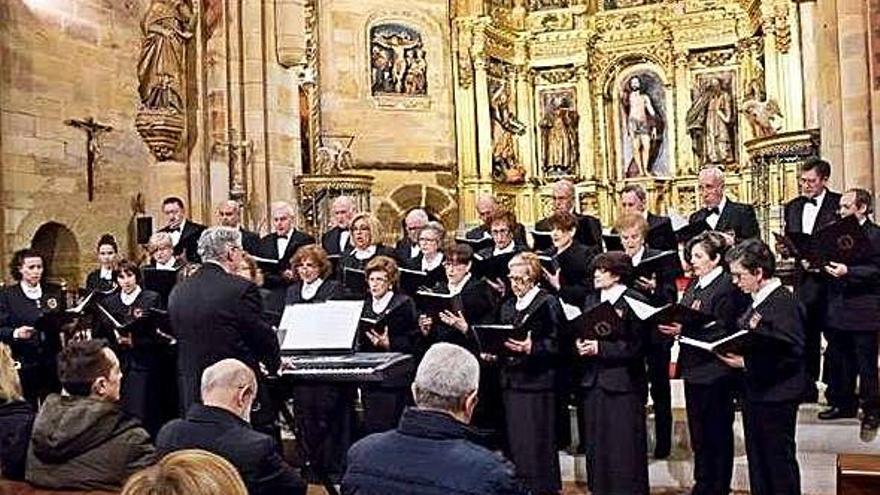 La Coral Benaventana interpretando parte de su repertorio en la iglesia Santa María ante la corporación municipal.