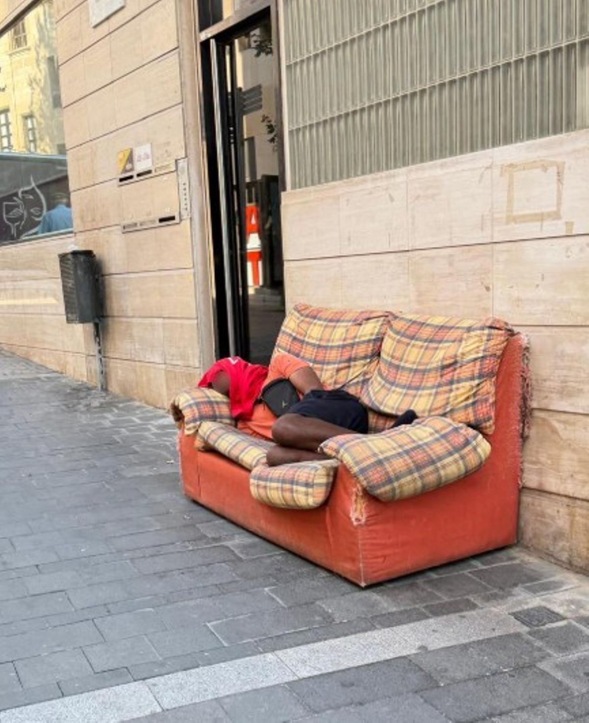 Una persona dormint a un banc del passeig de la República aquest dimecres