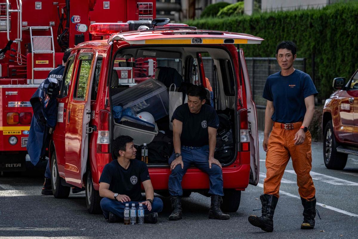 Los bomberos descansan frente al Yatsushiro Mill de Nippon Paper Industries en Yatsushiro, prefectura de Kumamoto, el 29 de julio de 2026, después de que un terremoto sacudió el suroeste de Japón el día anterior. (Foto de Yuichi YAMAZAKI / AFP)