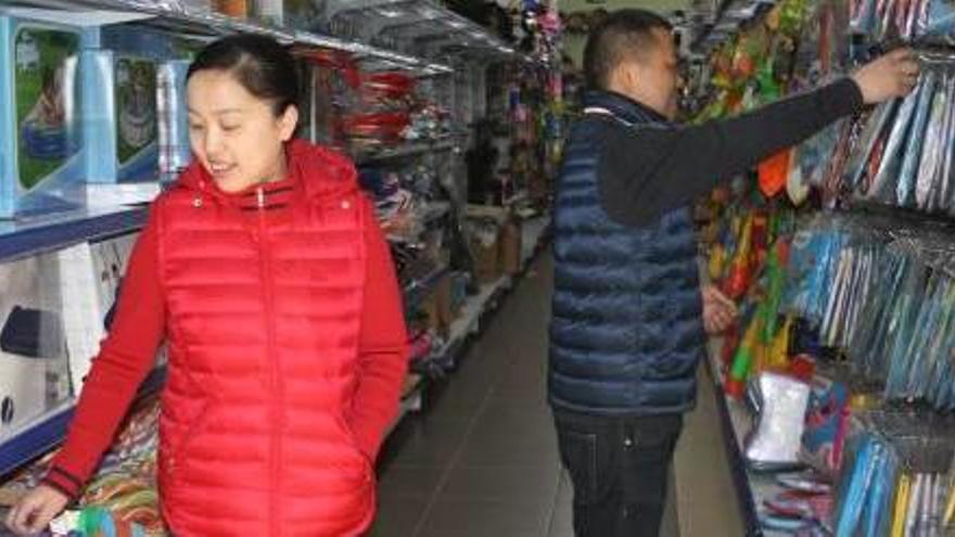 Propietaris del basar xinès dels Trullols col·locant productes a les prestatgeries