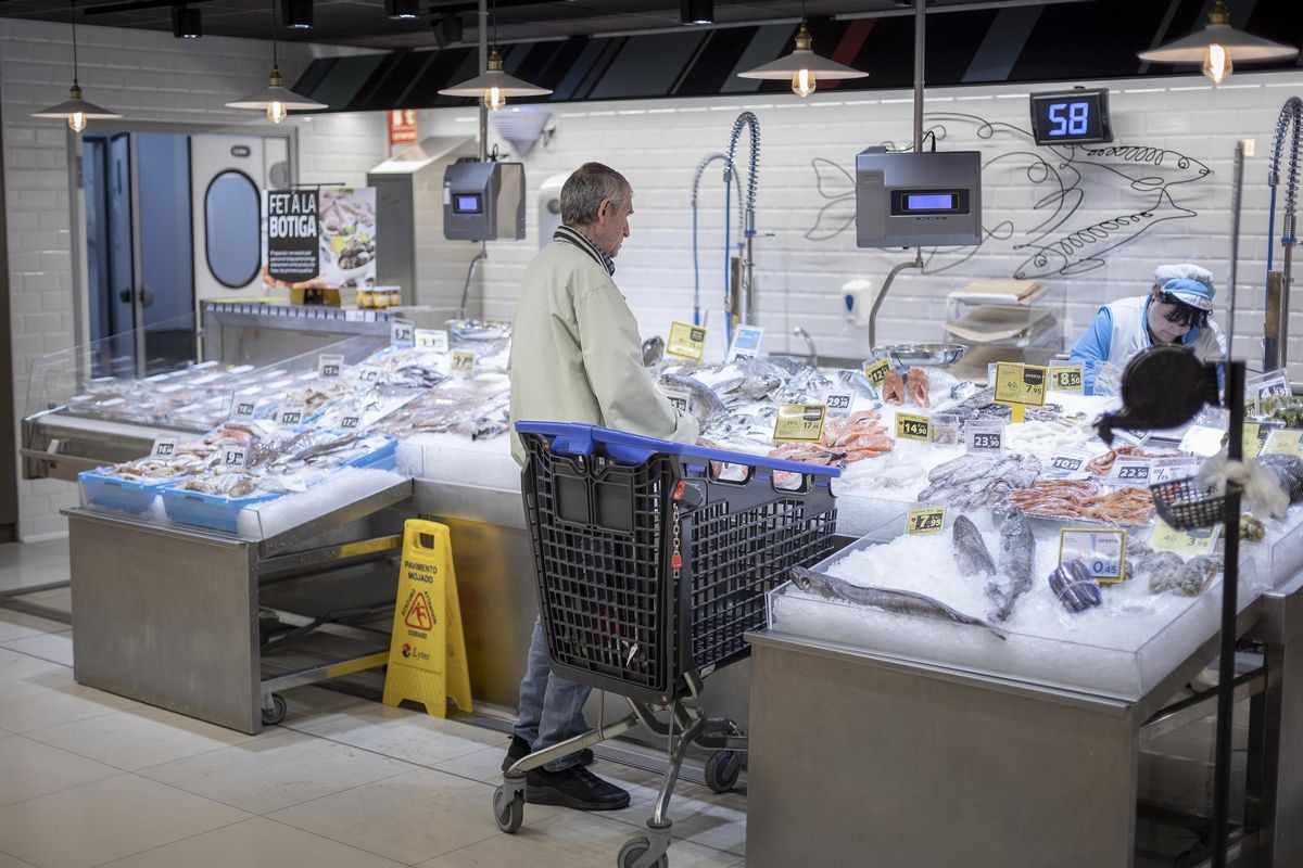 Un cliente compra en la pescadería de un supermercado Caprabo de Barcelona Un cliente compra en la pescadería de un supermercado Caprabo de Barcelona