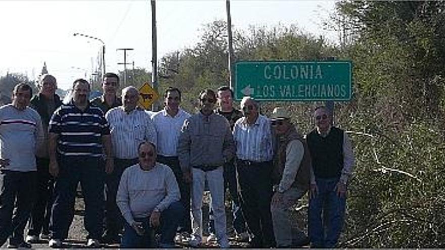 Vecinos de la localidad argentina de San Juan posan ante el cartel de la &quot;Colonia Los Valencianos&quot;.