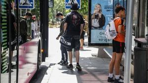 Jóvenes suben a un autobús urbano en una parada del centro de Cáceres.