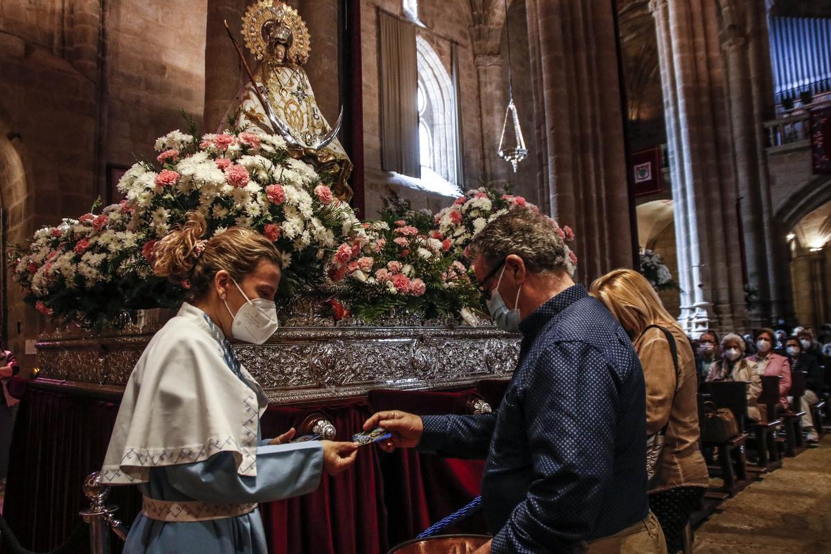 La patrona recibe a los fieles bajo el altar, de frente.