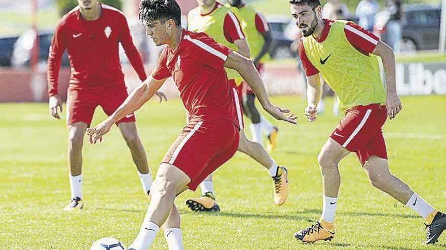 Cristian Salvador, presionado por Moi Gómez, en el entrenamiento de ayer en uno de los campos de Mareo.