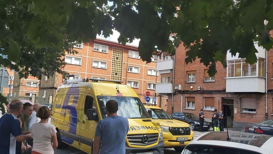 Vecinos, bomberos y policías locales, con el portal donde se produjo el derrumbe al fondo. | E. P.