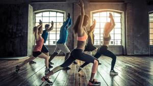 Gente practicando deporte en un gimnasio.