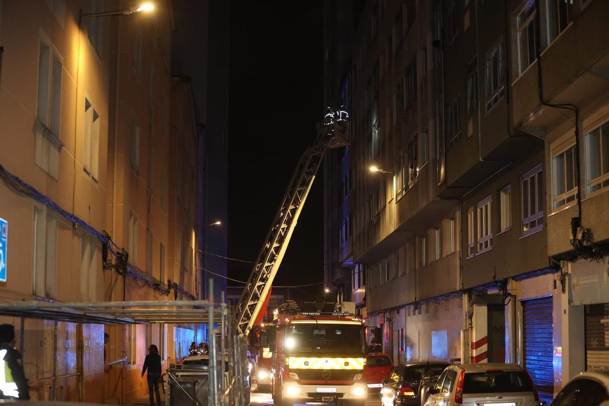 Los bomberos de A Coruña intervienen con la autoescalera en el incendio en un edificio en la Sagrada Familia en el que ha fallecido una persona y otra se encuentra en estado crítico.