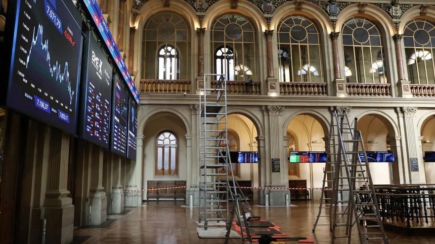 Varias escaleras frente a dos paneles del Ibex 35, en el Palacio de la Bolsa, en Madrid (España).