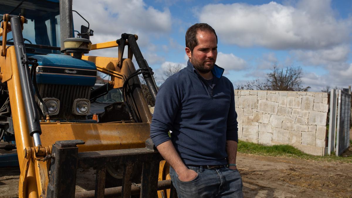 Manuel Vicente, pensativo, delante del tractor