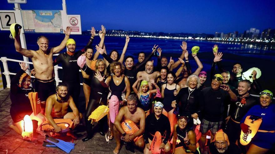 Los nadadores de la escalera 2 de la playa de San Lorenzo despiden el verano en Gijón con su travesía nocturna: "Es un momento de alegría"