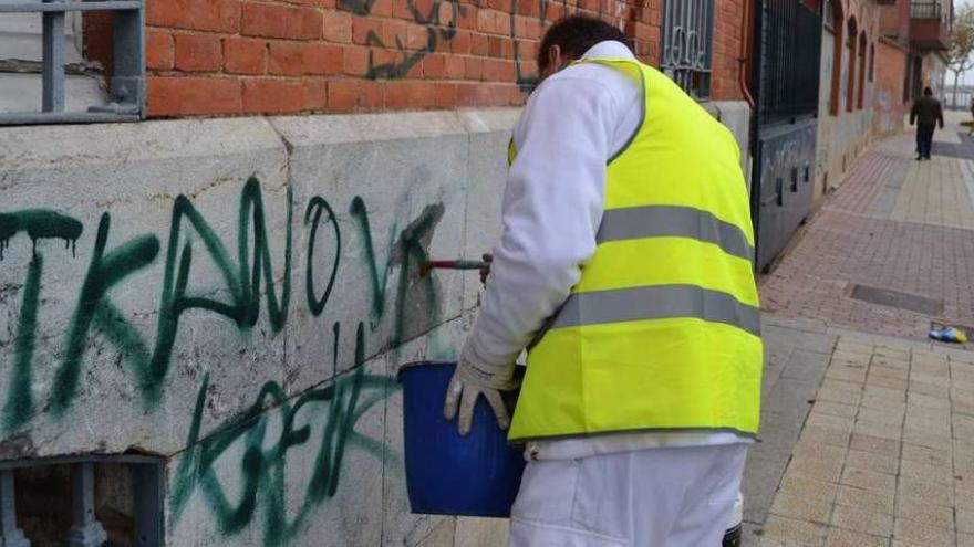 Un operario repasa con un pincel las letras de un grafiti en los paseos de La Mota para intentar eliminarlo.