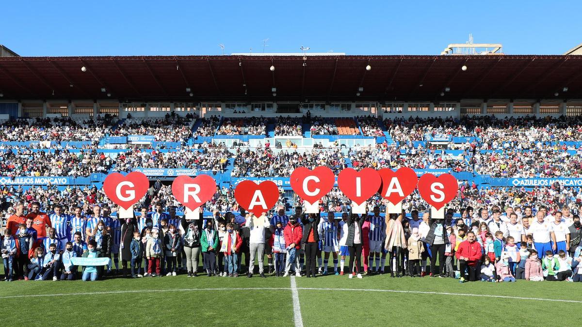 Los jugadores y niños de Aspanoa en el partido celebrado el año pasado en La Romareda