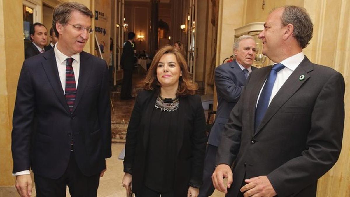 La vicepresidenta Soraya Sáenz de Santamaría, flanqueada por los presidentes gallego y extremeño, Alberto Núñez Feijóo y José Antonio Monago, este lunes en Madrid.