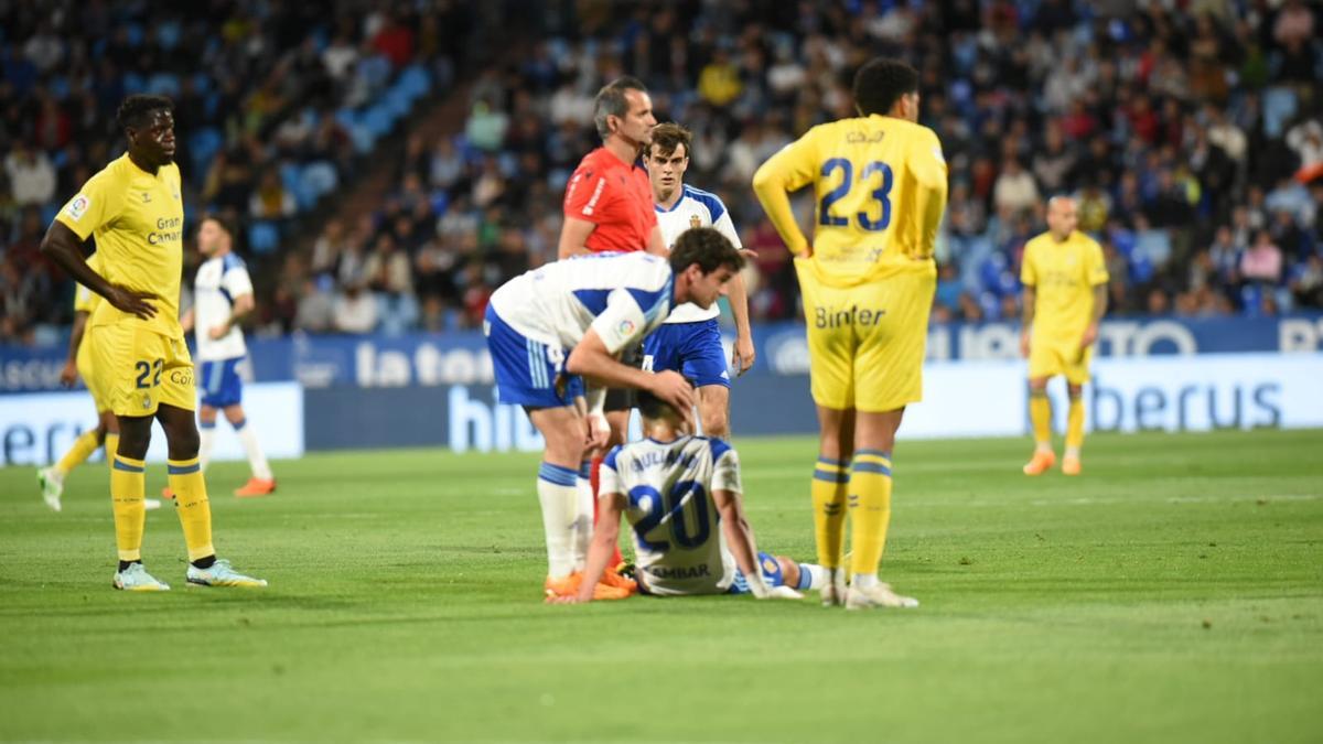 Azón tiene un gesto cariñoso con Giuliano mientras lo atienden los médicos del Real Zaragoza