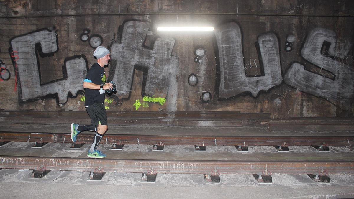 Un participante de la la Cursa del centenari del metro de Barcelona recorre los últimos metros de la prueba.